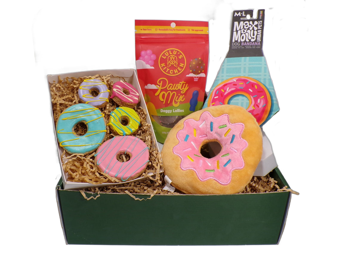 Open Donut Doggy Box showing donut toy, treats, and bandana.